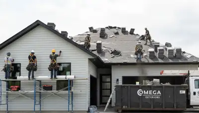 Roof replacement contractors installing new shingles on Atlanta GA home exterior