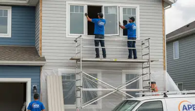 Technician repairing residential window frame in Atlanta GA for Next Level Exteriors vinyl siding service
